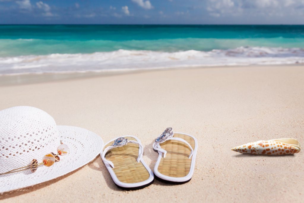 Strand mit Hut und Sandalen